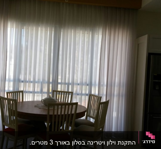 וילון לבן שקוף תלוי על חלון גדול